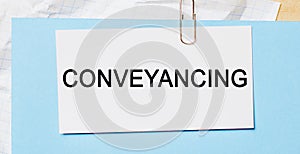 Text Conveyancing on a white card on a blue background. Business concept