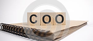 Text coo on the wooden cubes and craft colored notepad on the white background