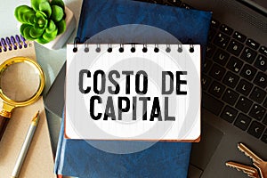 text COSTO DE CAPITAL written on notebook with chart,calculator and dollars photo