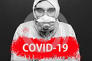 Text covid-19 on red warning sign on portret of man in biohazard chemical protective suit and face mask. Coronavirus pandemic