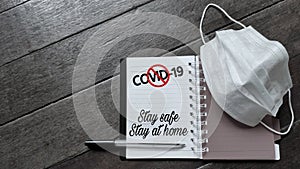 text covid-19 stay safe stay at home with stop sign written on notepad