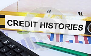 Text Credit Histories on the folder that is located on the financial diagrams with green pen and calculator photo