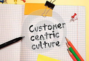 Text CUSTOMER CENTRICITY on white paper on clipboard with chart and calculator.