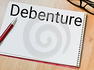 Text debenture written on note book.