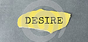 The text DESIRE. behind torn yellow