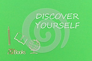 Text discover yourself, school supplies wooden miniatures on green background