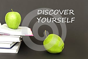 Text discover yourself, two green apples, open books with concept