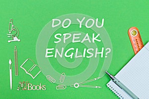 Text do you speak english, school supplies wooden miniatures, notebook with ruler, pen on green backboard