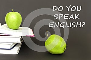 Text do you speak english, two green apples, open books with concept