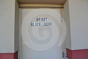 Text on a Door Stating `Do Not Block Door`