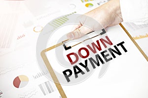 Text DOWN PAYMENT on white paper plate in businessman hands with financial diagram. Business concept