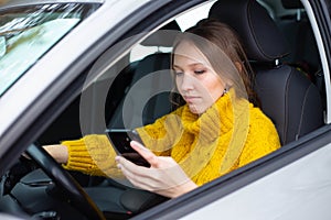 Text and drive woman. A woman is texting on her phone while driving