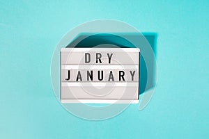 Text Dry January on the decorative lightbox isolated on blue background, mindful drinking