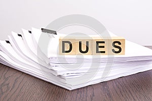 text DUES on wooden cubes, business analysis concept