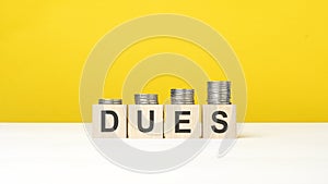 text dues on wooden cubes on yellow background