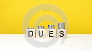 text dues on wooden cubes on yellow background photo