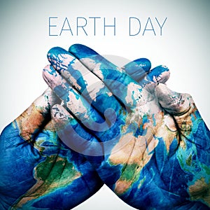 text earth day and man hands patterned with a world map (furnished by NASA)