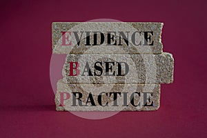Text EBP Evidence-based practice concept on brick blocks. Beautiful red background.