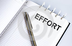 Text EFFORT on the short note texture background with pen