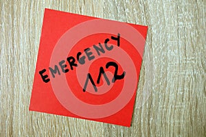 Text emergency 112 written on red sticker, closeup