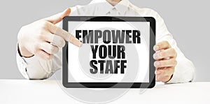 Text EMPOWER YOUR STAFF on tablet display in businessman hands on the white background. Business concept