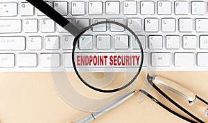 Text ENDPOINT SECURITY on keyboard with magnifier , glasses and pen on beige background