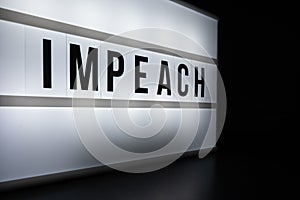 Text in english on lightbox sign spelling Impeach.