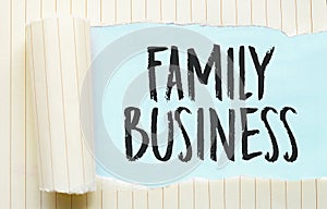 The text FAMILY BUSINESS appearing behind torn white paper