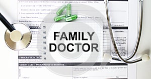 Text Family Doctor in a notebook on medical forms with a phonendoscope and green pills