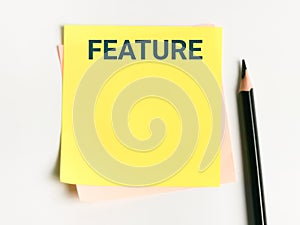 Text FEATURE written on sticky note.