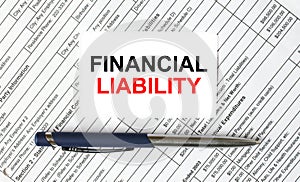 Text Financial Liability written on a business card lying on financial tables with a blue metal pen