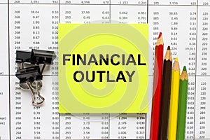 Text Financial Outlay on financial tables with pencils, glasses and paper clips photo