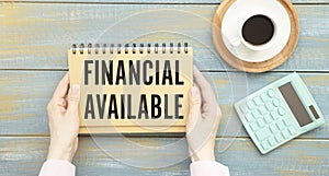 Text FINANCING AVAILABLE on notepad with office tools, pen on financial report . Business and financial conzept. photo