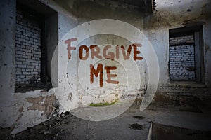 Text forgive me on the dirty old wall in an abandoned house