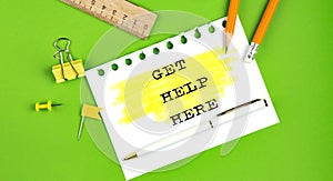 Text GET HELP HERE sign showing on green background with office tools