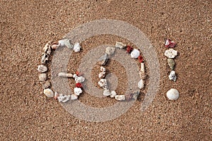 Text Go on sandy beach made from shells. photo