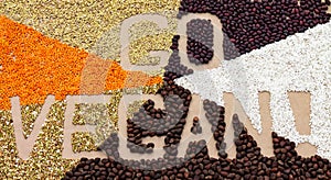 Text Go Vegan lined with various cereals and nuts on a craft paper background. Food lettering.