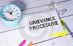 Text grievance procedure on notepad with office tools, pen on financial report . Business and financial conzept.