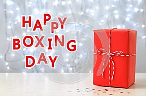 Text Happy Boxing Day near gift against lights