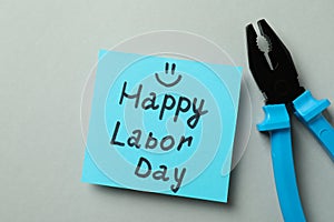 Text Happy Labor Day and pliers on gray background