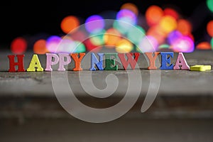 Text Happy New Year of bright multicolored wooden letters