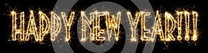 Text Happy New Year written sparkling sparklers . Lettering isolated on black background. Beautiful glowing overlay template for