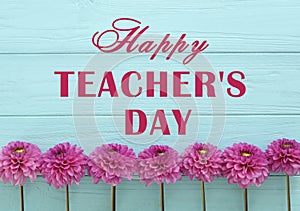 Text Happy Teacher`s Day and beautiful flowers on light blue wooden table, top view