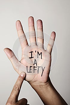 Text I am a lefty in the palm of the hand