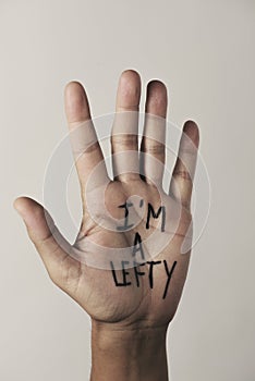 Text I am a lefty in the palm of the hand photo