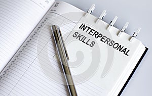Text Interpersonal skills on the short note texture background with pen. Business concept