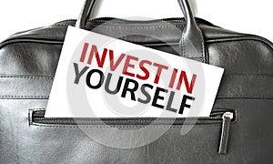 Text Invest in Yourself writing on white paper sheet in the black business bag. Business concept