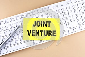 Text JOINT VENTURE text on a sticky on keyboard, business concept