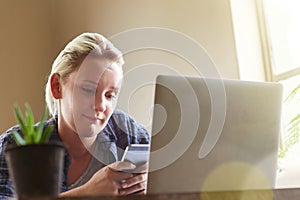 Text Just chilling at home. What are you up to. a young woman sending a text message while sitting at her laptop at home