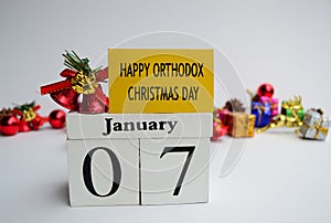 Text label and cube 7th January with blurred christmas ornament background, Happy Orthodox Christmas Day